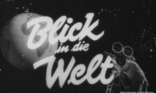 Black and white image with the German text Blick in die Welt. A person with a film camera stands beside a large globe illustration. The words Historisches Archiv Krupp appear in the bottom right corner.